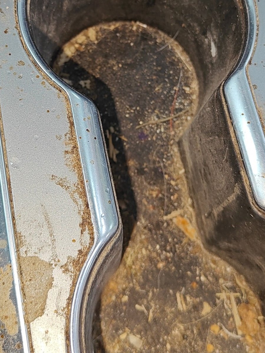 Center console cup holders before detailing, packed with dirt, crumbs and debris